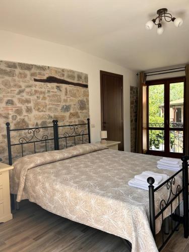 a bedroom with a large bed and a stone wall at Agriturismo Nonno Ninuccio in Gioi