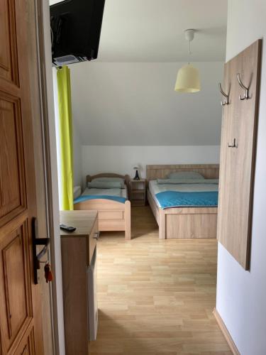 a bedroom with two beds and a television in it at Pokoje na Brzozowej 2 in Białogóra