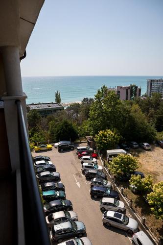 a row of cars parked in a parking lot near the ocean at Bendita Mare Aparthotel in Golden Sands