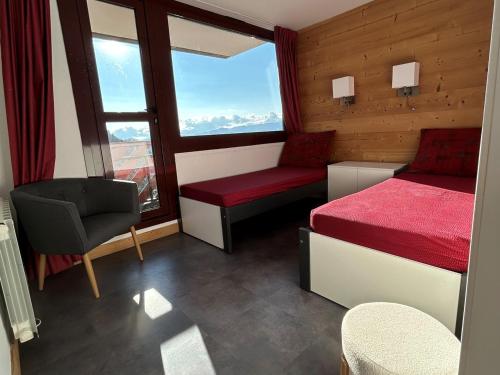 une chambre avec un lit, une chaise et une fenêtre dans l'établissement Spacieux appart rénové, 3 pièces + cabine, proche pistes, 8 pers, animaux admis - FR-1-181-1913, à La Plagne Tarentaise