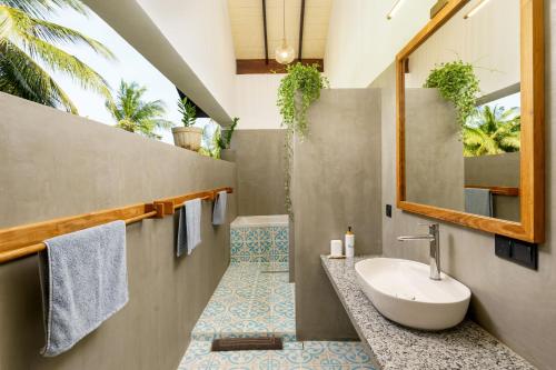 a bathroom with a sink and a mirror at Kandakuliya Sunrise Beach Villas in Kalladi