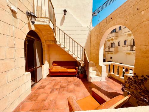 an outdoor patio with a couch in a building at See You Mystic Flowers in Għarb