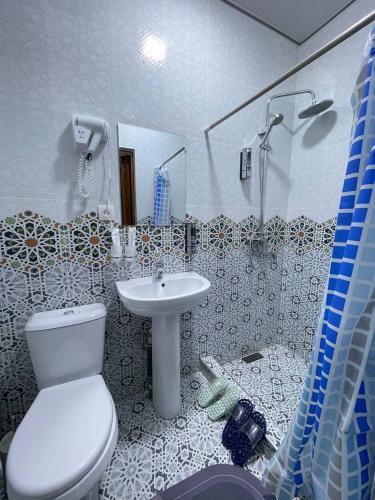 a bathroom with a toilet and a sink at Kifoyat Hotel in Samarkand