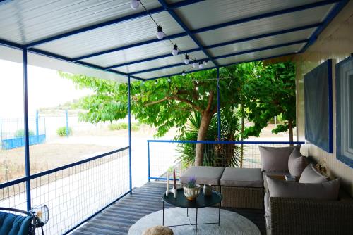 a screened in porch with a couch and a table at Seaside Garden Galaxidi in Galaxidhion