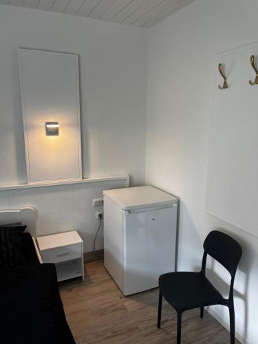 a room with a chair and a dresser and a mirror at Pension Plesse-Blick Bovenden in Bovenden