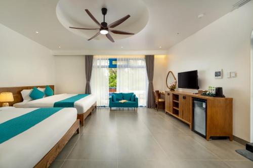 a hotel room with two beds and a ceiling fan at The Linh Coastline Villa in Hoi An