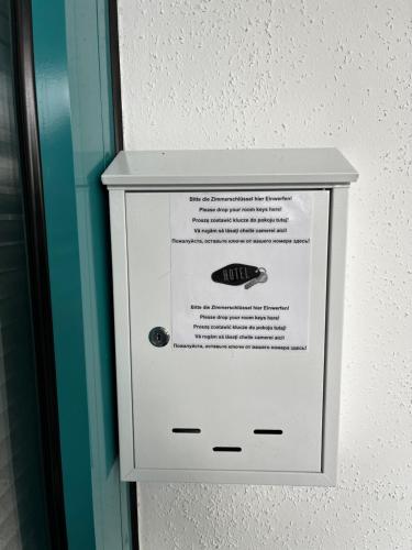 a white box with a sign on a wall at Pension Plesse-Blick Bovenden in Bovenden