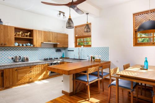 a kitchen with wooden cabinets and a wooden table at Kandakuliya Sunrise Beach Villas in Kalladi