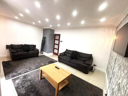 ホーンチャーチにあるLuxury 4 Bedroom House with Free Parkingのソファとテーブルのあるリビングルーム