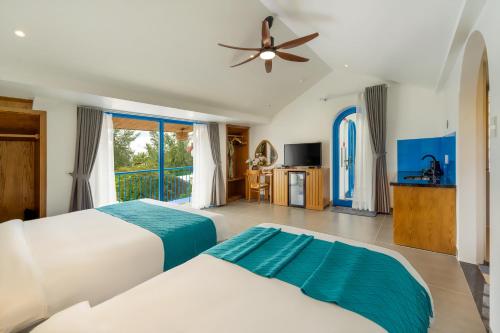 a bedroom with two beds and a ceiling fan at The Linh Coastline Villa in Hoi An