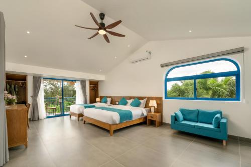a bedroom with two beds and a ceiling fan at The Linh Coastline Villa in Hoi An