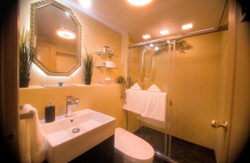a bathroom with a sink and a toilet and a mirror at Spacious vintage styled basement apartment - private in Calgary