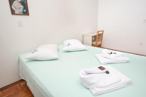 a white bed with white towels on top of it at Casa Santa Cruz in Passo Fundo