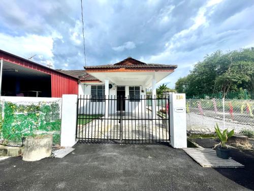 a house with a gate and a red building at 11Acozy#6pax#singlestoreyhouseAlmaBukitMertajam in Bukit Mertajam