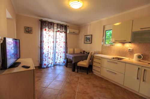 a kitchen with a table and a dining room at Yu&li Rose Apartments Adriatic in Bar
