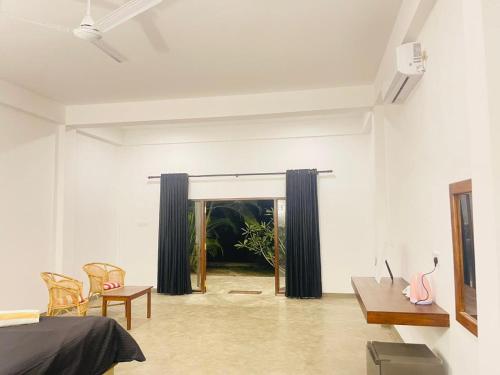 a bedroom with a bed and a table and chairs at Ashansa Lagoon Resort in Tangalle