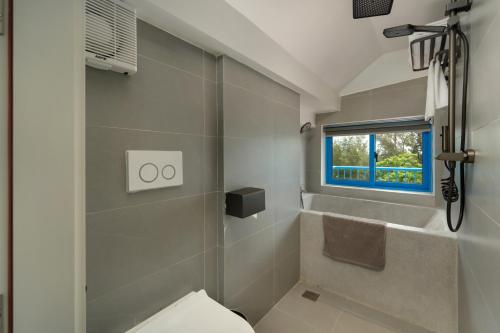 a bathroom with a toilet and a window at The Linh Coastline Villa in Hoi An
