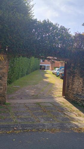 a stone wall with an arch over a driveway at Casa com piscina para até 6 pessoas com duas camas de casal e sofá-cama casal in Serra Negra