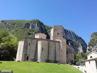 a castle sitting on top of a lush green hill at Libera Mente in Fabriano