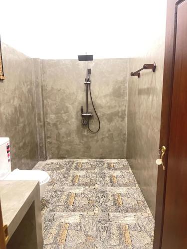 a bathroom with a shower and a toilet at Ashansa Lagoon Resort in Tangalle