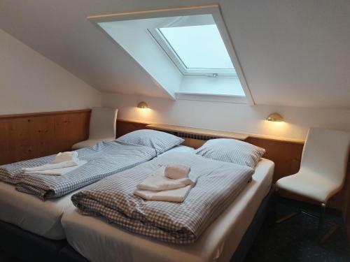 a bedroom with two beds and a skylight at Haus Obermaiselstein in Obermaiselstein