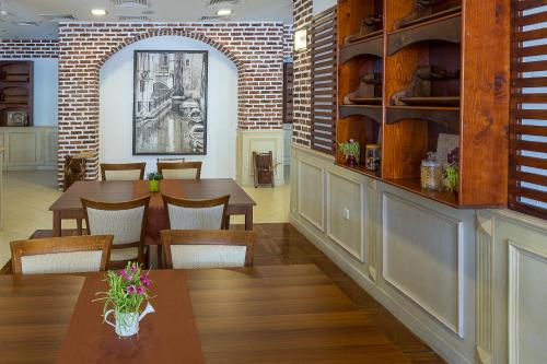 a restaurant with tables and chairs and a brick wall at Bendita Mare Aparthotel in Golden Sands