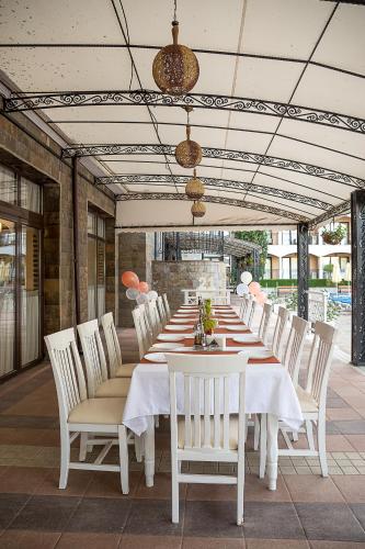 a long table with white chairs on a patio at Bendita Mare Aparthotel in Golden Sands