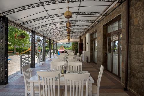 a restaurant with white tables and chairs on a patio at Bendita Mare Aparthotel in Golden Sands