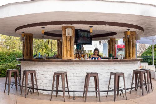 a woman standing behind a bar with stools at Bendita Mare Aparthotel in Golden Sands