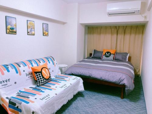 um quarto com duas camas e um sofá em Shinjuku House-1 em Tóquio