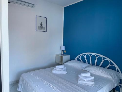 a blue bedroom with a bed with towels on it at CannetoMare in Canneto