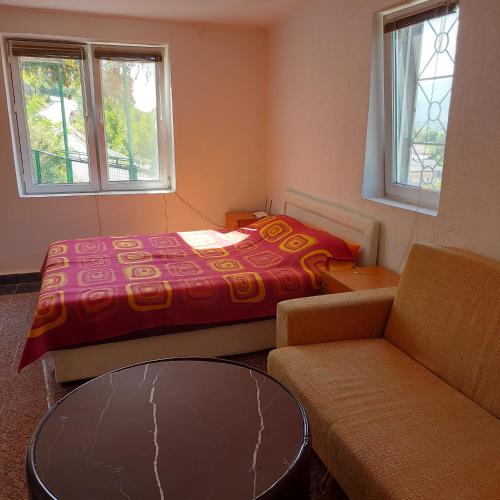 a bedroom with a bed and a couch and a table at Studio Relax in Travnik