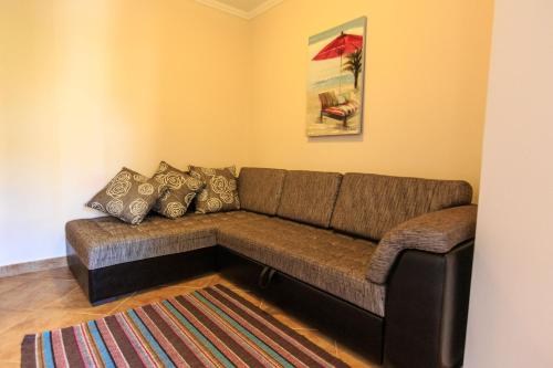 a brown couch in a living room with a rug at Yu&li Rose Apartments Adriatic in Bar