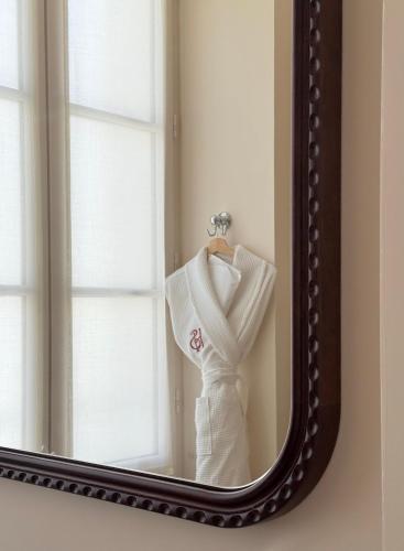 a white dress hanging in front of a mirror at Hotel de Silhouette in Biarritz