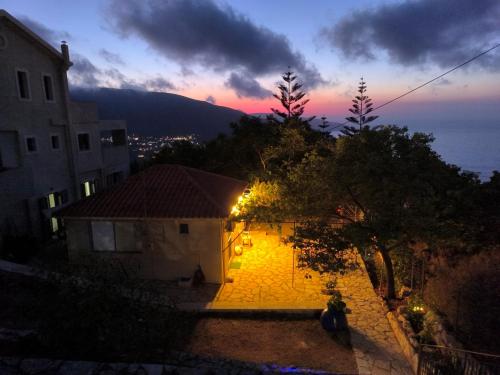 a view of a building with a sunset in the background at Sofias house at Agkona Kefalonia in Angón