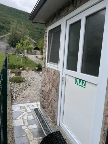 a white garage door with a sign on it at Apartman Azra in Kulen Vakuf