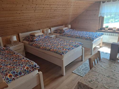 a room with three beds in a log cabin at Drewniany Domek Daria i Tomek 2 domki na 8 osób in Stronie Śląskie