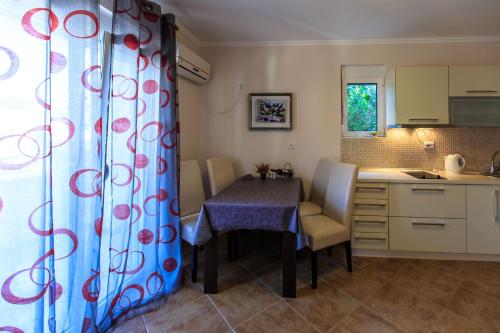 a small kitchen with a table and a table and chairs at Yu&li Rose Apartments Adriatic in Bar