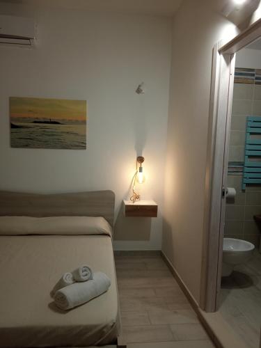 a bedroom with a bed and a bathroom with a sink at Floras dream in Santa Maria di Castellabate