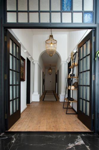 an empty hallway with a chandelier and a room with doors at Paarl Hideaway in Paarl