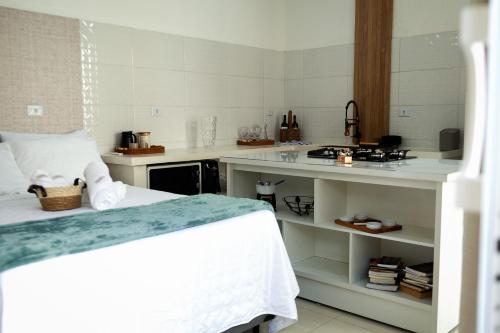 a room with a bed and a kitchen with a counter at Estúdio privativo para hóspedes in São Roque