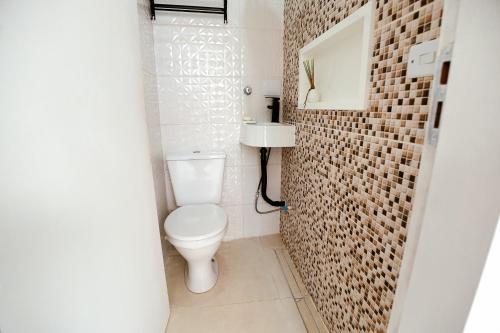 a small bathroom with a toilet and a sink at Estúdio privativo para hóspedes in São Roque