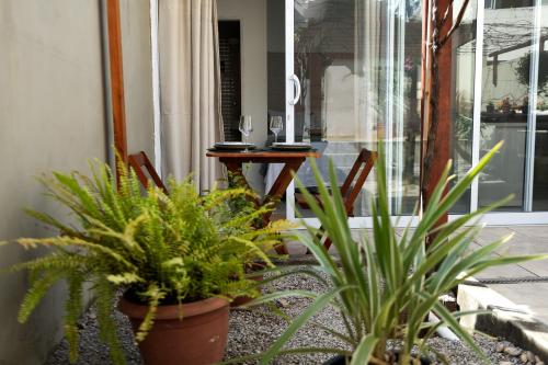 a patio with plants and a table and chairs at Estúdio privativo para hóspedes in São Roque