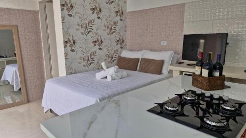 a bedroom with a bed with towels and wine bottles at Estúdio privativo para hóspedes in São Roque