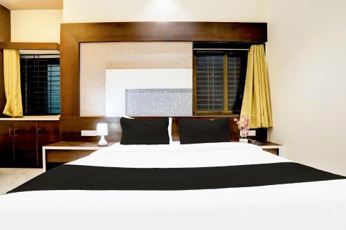 a bedroom with a large white bed and two windows at Hotel O Yuvraj Dhage Plot Shivshakti Maidan in Bārsi