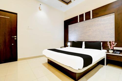 a bedroom with a large bed and a wooden headboard at Hotel O Yuvraj Dhage Plot Shivshakti Maidan in Bārsi