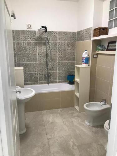 a bathroom with a tub and a sink and a toilet at CasaDiFlavio in Torvaianica