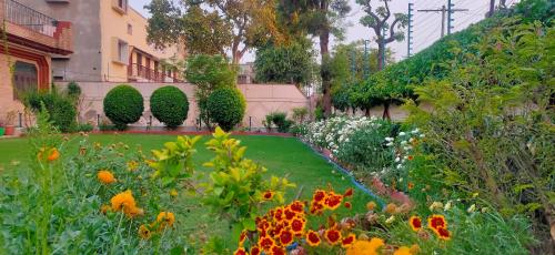 a garden with flowers and plants in front of a building at Kosmic Stays in Mathura