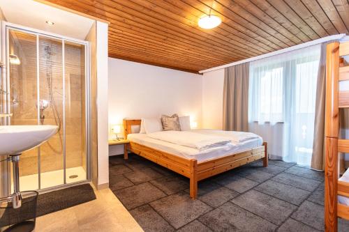 a bedroom with a bed and a sink in it at Gästehaus Dreier in Neukirchen am Großvenediger