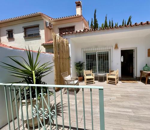 a house with a patio with chairs and a fence at La Brisca Sun & Soul Pedregalejo in Málaga